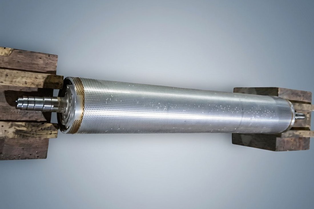 Licker-in roller with all pins removed, showing the bare body and pin seat pattern during re-pinning inspection